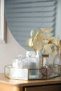 Containers with cotton swabs, pads and burning candle near cosmetic products on dressing table Royalty Free Stock Photo