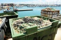 Containers full of deteriorated fishing nets and plastic floats for recycling in a fishing port