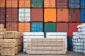 Containers and neatly stacked timber stock.