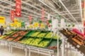 Containers with vegetables and fruits in a supermarket. Large department with a huge selection. Blurred