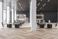 Contemorary grey coworking office interior with wooden flooring, daylight and city view. Business interiors concept. Royalty Free Stock Photo