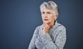 Contemplating the day away. Studio shot of a cheerful elderly woman standing and thinking while looking into the Royalty Free Stock Photo