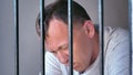 Contemplation Behind Prison Bars: Man in Deep Emotional Turmoil