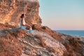 Contemplation nature and keeping diary concept, copy space. Woman on cliff enjoying landscape and writing in notebook. Royalty Free Stock Photo