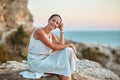 Contemplation time and self absorbed idea, copy space. Pretty lady in dress resting on rock. Pensive woman looking away. Royalty Free Stock Photo