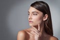 Contemplative beauty. Studio shot of a beautiful young woman posing against a gray background. Royalty Free Stock Photo