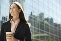 Contemplative Businesswoman With Drink Outside Building