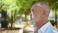 A contemplative middle-aged man with grey beard and bald head in a serene park setting Royalty Free Stock Photo
