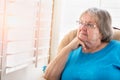 Contemplative Senior Woman Gazing Out of Her Window