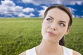 Contemplative Woman in Grass Field Looking Up and Over Royalty Free Stock Photo