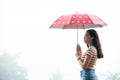Contemplative woman with a red umbrella enjoying the solitude of a foggy day Royalty Free Stock Photo
