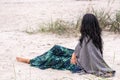 Contemplative woman sitting on the beach, her gaze lost in the horizon, embodies a moment of peaceful reflection and Royalty Free Stock Photo