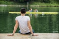 Contemplative young man sitting beside river Royalty Free Stock Photo