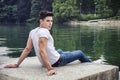 Contemplative young man sitting beside river Royalty Free Stock Photo