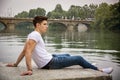 Contemplative young man sitting beside river Royalty Free Stock Photo