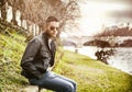 Contemplative young man sitting beside river Royalty Free Stock Photo