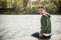 Contemplative young man sitting beside river in Turin Royalty Free Stock Photo