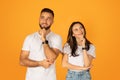 Contemplative young man and woman in white t-shirts, with hands on chin, looking upwards thoughtfully Royalty Free Stock Photo