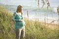 Contemplative young pregnant woman at beach Royalty Free Stock Photo
