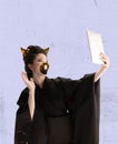 Contemporary art collage. Creative design. Beautiful young woman in image of geisha in kimono with cat& x27;s mouth and