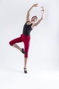 Contemporary Ballet of Flexible Athletic Man Posing in Red Tights in Ballanced Dance Pose With Hands Lifted in Studio