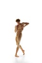 Contemporary ballet. Talented, shirtless man, ballet dancer in beige pants dancing in motion against white studio