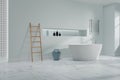 Contemporary bathroom blue interior, with floor tub and wooden ladder for towel Royalty Free Stock Photo