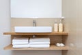 Contemporary bathroom with an empty wall and a small shelf holding neatly folded towels. Generative AI