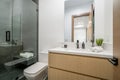 Contemporary bathroom features a white toilet, shower with a glass door