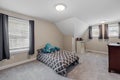 Contemporary bedroom interior with gray carpeting and blue pillows on a bed. Royalty Free Stock Photo