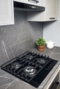 Contemporary black tempered glass gas stove hob with four burners with auto ignition knob cast iron pan supports fan Royalty Free Stock Photo