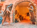 Contemporary ceramic sculpture of two men standing together in an archway at kilometer zero