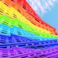 Contemporary collage. View of buildings in rainbow colors against a blue sky with clouds. LGBT concept, architecture