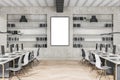 Contemporary concrete coworking office interior with blank white mock up poster, multiple workplaces and bookcase shelves with Royalty Free Stock Photo