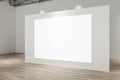 Contemporary concrete gallery interior with wooden parquet flooring, lights and blank white mock up banner on wall. Exhibition Royalty Free Stock Photo