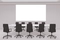 Contemporary concrete office meeting room interior with blank white mock up poster on wall, furniture, daylight, and equipment. Royalty Free Stock Photo