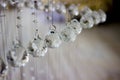 Contemporary crystal chandelier in room interior. Close up. Crystals suspended on a string. Crystal Chandelier
