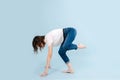 Contemporary dancer standing on two hands and a leg, shifing her weigth forward.