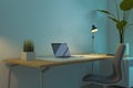 Contemporary dark blue designer office workplace with various items, laptop, decorative plant and lamp. Workspace and home concept Royalty Free Stock Photo