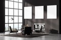 Contemporary dark grey living room interior with fireplace, armchairs. Three posters in a row template mockup on wall. Big Royalty Free Stock Photo