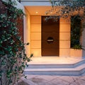 Contemporary design house entrance dark brown door, illuminated early in the evening