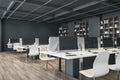 Contemporary designer coworking office interior with wooden flooring, furniture, bookcase and equipment.