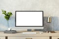 Contemporary designer desktop with empty white computer monitor, lamp, supplies and other items. Concrete wall background. Mock up Royalty Free Stock Photo