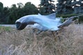 Contemporary garden sculpture of cramp fish in waves of grasses landart