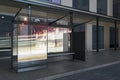 Contemporary glass bus stop with city reflections and daylight. Transport and urban concept. Royalty Free Stock Photo