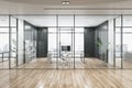 Contemporary glass office corridor with furniture and wooden flooring.