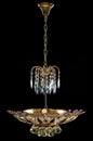 Contemporary gold chandelier isolated on black background. Crystal chandelier decorated purple crystals Royalty Free Stock Photo