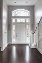 Contemporary home with minimal furnishings and decor light wood floor stairs white walls large windows with black frames Royalty Free Stock Photo