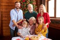 Contemporary large multi-generation family sitting by served festive table on Christmas day Royalty Free Stock Photo