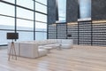 Contemporary library interior with tall bookshelves, panoramic windows, lounge area and wooden flooring. Royalty Free Stock Photo
